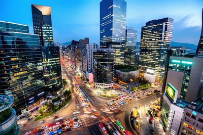 High angle view of illuminated city street and buildings at night