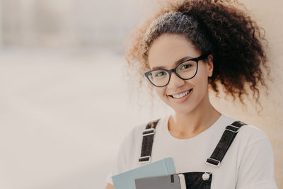 Portrait of smiling young woman using smart phone