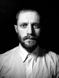 Portrait of young man against black background