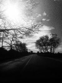 Empty road along bare trees