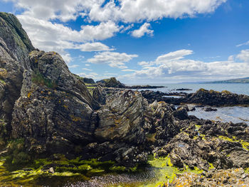 Rock formations by sea against sky