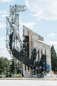 View of statue by building against sky