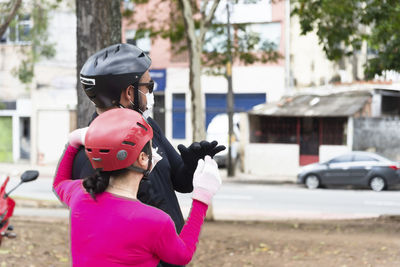 Man and woman in uniform and helmet looking to the side.