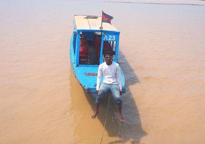 Man standing on boat in sea