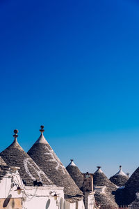 Buildings in town against clear blue sky