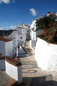 Houses and buildings in town against blue sky