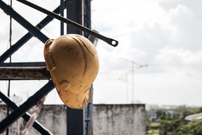 Low angle view of rusty metal against building