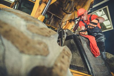 Low angle view of mechanic repairing land vehicle