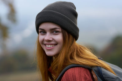 Portrait of smiling young woman in park during winter