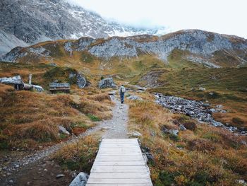 Boardwalk amidst grass against sky