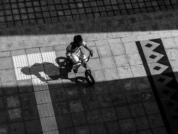 High angle view of boy riding bicycle on street