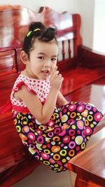 Cute girl sitting on table at home