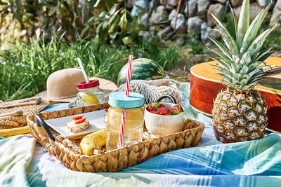 Summertime healthy picnic. fresh tropical fruit, sweet stawberry sandwiches and refreshing drink