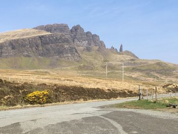 Scenic view of road by mountain against sky