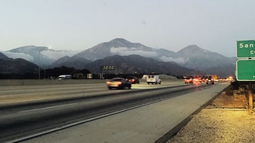 Cars on road against mountain range