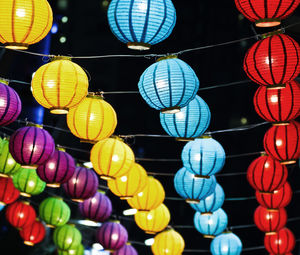 Low angle view of illuminated lanterns hanging at night