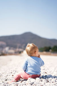 Boy on beach against clear sky