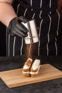 Dessert tiramisu cake on a tray on a dark background