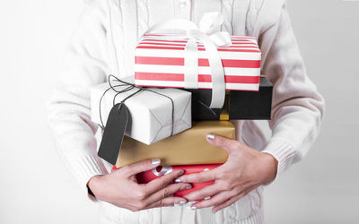 Midsection of man holding red box against white background