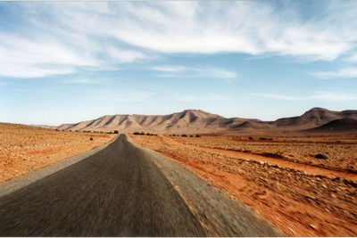 Empty road along countryside landscape