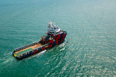 Tugboat floating in green sea aerial view