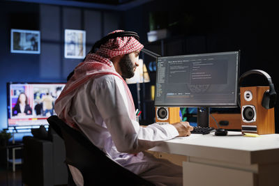 Rear view of man using laptop