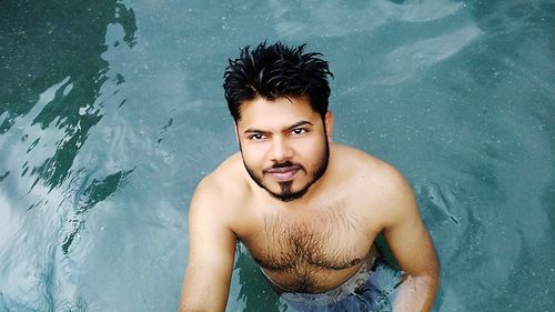 Portrait of shirtless young man in lake