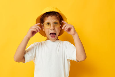 Portrait of cute girl against yellow background