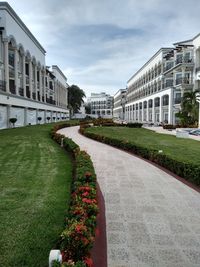 Lawn by building against sky in city