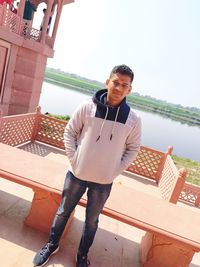 Portrait of young man standing against built structure