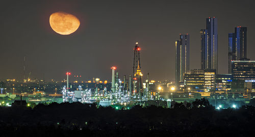 Illuminated cityscape against sky at night