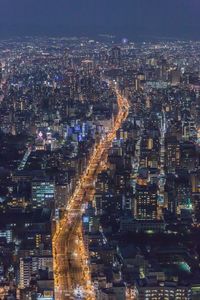 Illuminated cityscape against sky at night