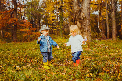 Full length of father and son on road during autumn