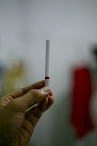 Close-up of hand holding cigarette