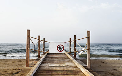 Wooden pier at the sea with danger sign -no access -