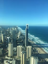 Aerial view of buildings in city against clear blue sky