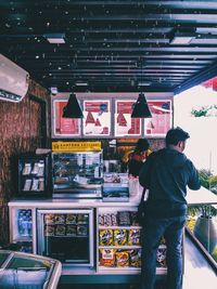Rear view of man standing in store