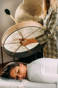 Sound therapy drum. playing native american hide drum in sound healing therapy