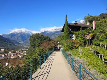 Panoramic view of buildings and mountains against blue sky