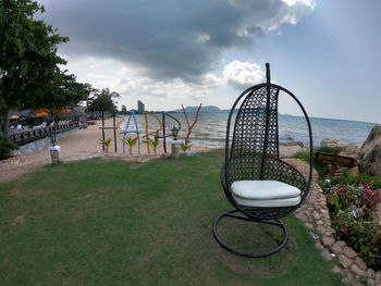 Chairs and tables in park against sky