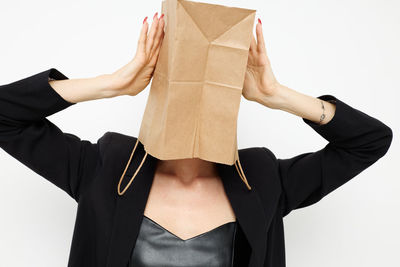 Woman covering face with paper bag