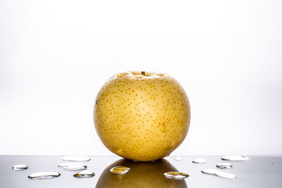 Close-up of lemon on table against white background