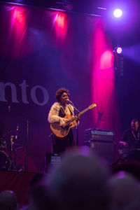People playing guitar at music concert