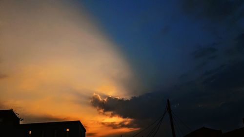 Low angle view of silhouette building against sky