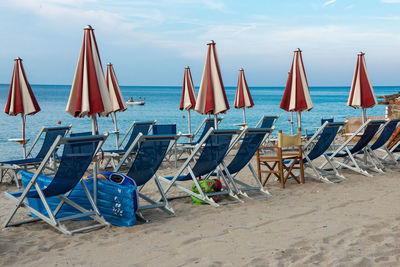 Closed canopies and sun loungers on beach