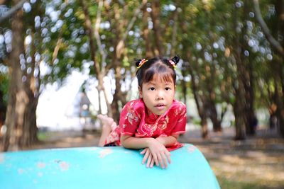 Cute girl lying on playing equipment at playground