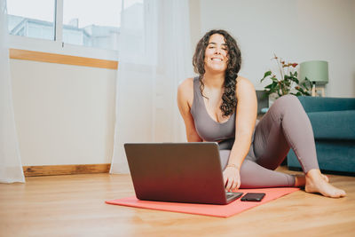 Young woman using laptop while sitting on table