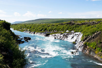 Scenic view of waterfall against sky