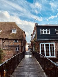 Footpath amidst buildings against sky