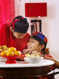 Siblings having food in container at table